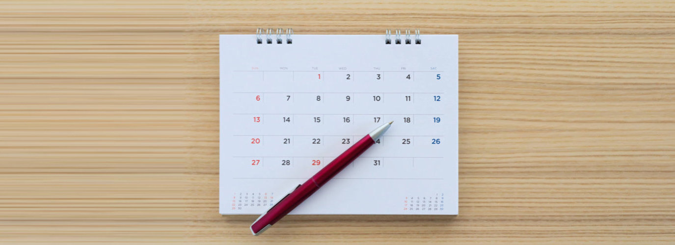 calendar with pen on wood table background